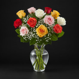 Mixed roses in a clear glass vase with baby's breath
