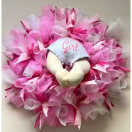 Pink decorative wreath with a baby doll in the center