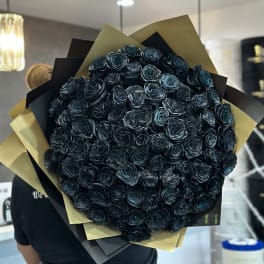 Large bouquet of dark blue-black roses wrapped in black and gold paper