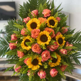 Standing bouquet of sunflowers and pink roses with lush greenery
