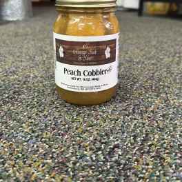 Jar of peach cobbler filling with a labeled metal lid