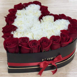 Heart-shaped box of red roses and white carnations with a red ribbon