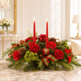 Red candle centerpiece with roses, carnations, pinecones, and ribbon