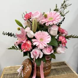 Pink bouquet with roses, gerbera daisies, lilies, and carnations in a painted pot
