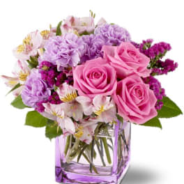 Pink and lavender bouquet in a square glass vase
