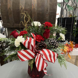 Holiday bouquet with red and white carnations in a red vase