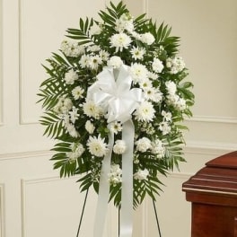 White funeral wreath with ribbon on a stand