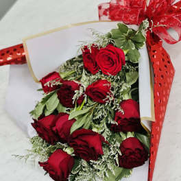 Bouquet of red roses wrapped in white paper with a red ribbon