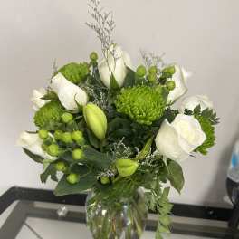 White roses and green chrysanthemums in a glass vase