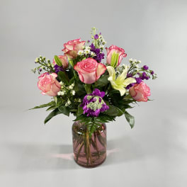 Pink roses and white lilies in a glass vase