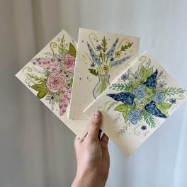 Hand holding three floral greeting cards with watercolor flowers