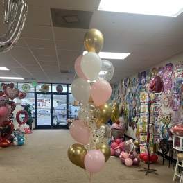 Cluster of pink, white, and gold balloons in a party store