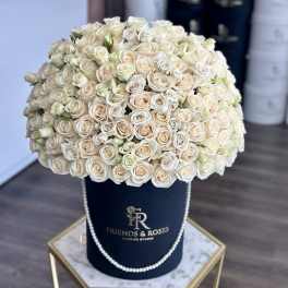 Large bouquet of cream and blush roses in a navy hat box