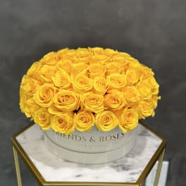Round bouquet of yellow roses in a white hat box