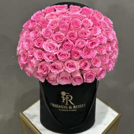 Round bouquet of bright pink roses in a black hat box