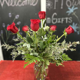 Red roses arranged in a clear glass vase