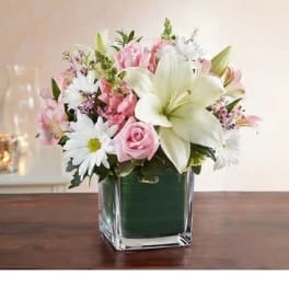 Pink and white flower arrangement in a square glass vase
