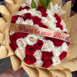 Bouquet of red and white roses wrapped in tan paper with a ribbon
