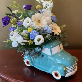 Flowers arranged in a turquoise truck-shaped vase