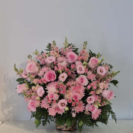 Large pink flower arrangement in a woven basket