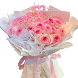 Bouquet of pink roses wrapped in pastel paper with a heart topper