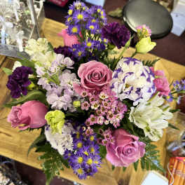 Mixed bouquet with pink roses, purple daisies, and white blooms