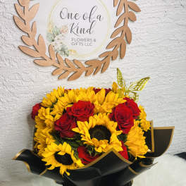 Bouquet of yellow sunflowers and red roses wrapped in black paper