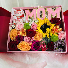 Gift box with pink MOM letters, roses, sunflowers, and chocolates
