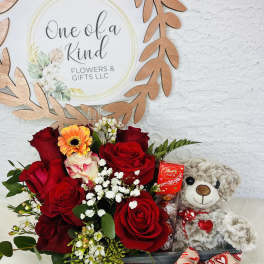 Red roses with a teddy bear and chocolates in a gift box