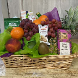 Gift basket with fruit, cookies, chocolate, and a pineapple