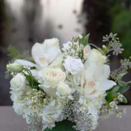 White floral arrangement in a clear square vase