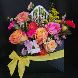 Mixed bouquet of roses and daisies in a black gift box with a yellow ribbon