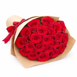 Bouquet of red roses wrapped in brown paper with a red ribbon