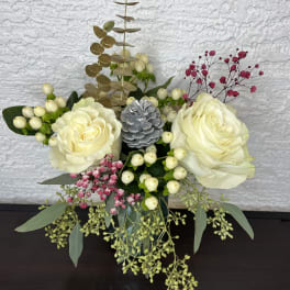 Cream rose arrangement with berries and eucalyptus in a vase