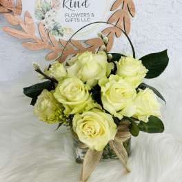 Pale yellow roses in a glass vase with a burlap bow
