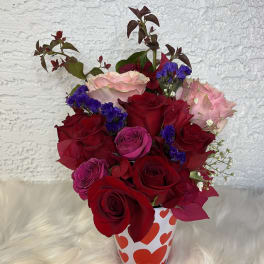 Bouquet of red and pink roses in a heart-patterned cup