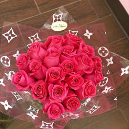 Bouquet of hot pink roses wrapped in clear cellophane with a white patterned design