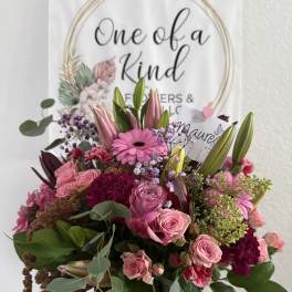Pink mixed flower bouquet in a glass vase with a gift card
