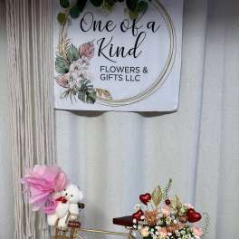 Gold bicycle decor with a small floral arrangement and teddy bear