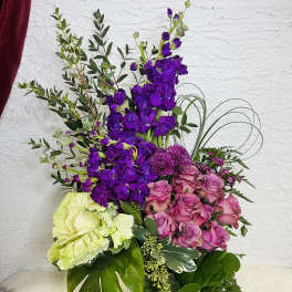 Purple and pink floral arrangement in a clear glass vase