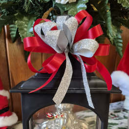 Black lantern with a Christmas village scene and red-silver ribbon bow
