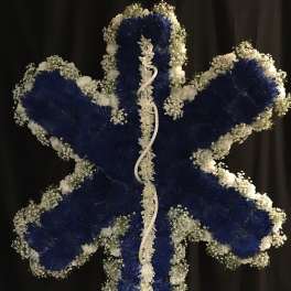 Blue and white floral standing spray shaped like a cross