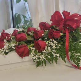 Long-stem red roses with baby's breath and a red ribbon on a white box