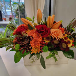 Orange lilies and red roses in a rectangular vase