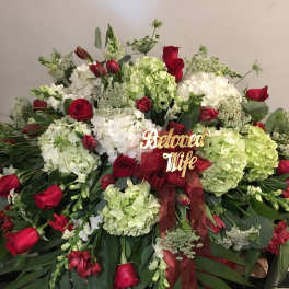 Large red and white floral spray with a ribbon and "Beloved Wife" sign