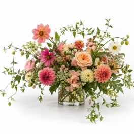 Mixed pink and peach flowers in a clear glass vase
