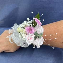 Pink and white wrist corsage with ribbon and pearl accents