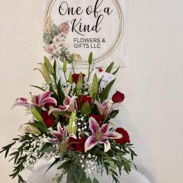 Bouquet of pink lilies and red roses in a glass vase