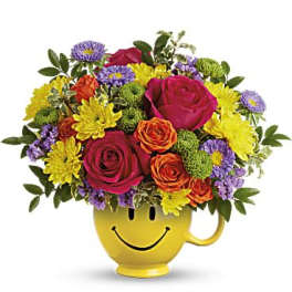 Bouquet of mixed flowers in a yellow smiley-face mug