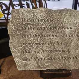 Engraved memorial stone with a quote on a stand